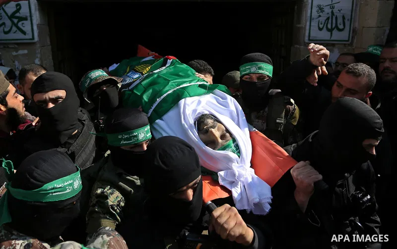 Palestinian militants from the Ezzedine al-Qassam Brigades, the armed wing of the Hamas movement carry the body of Hamas senior leader Imad al-Alami during his funeral outside the al-Omari mosque in Gaza City on January...