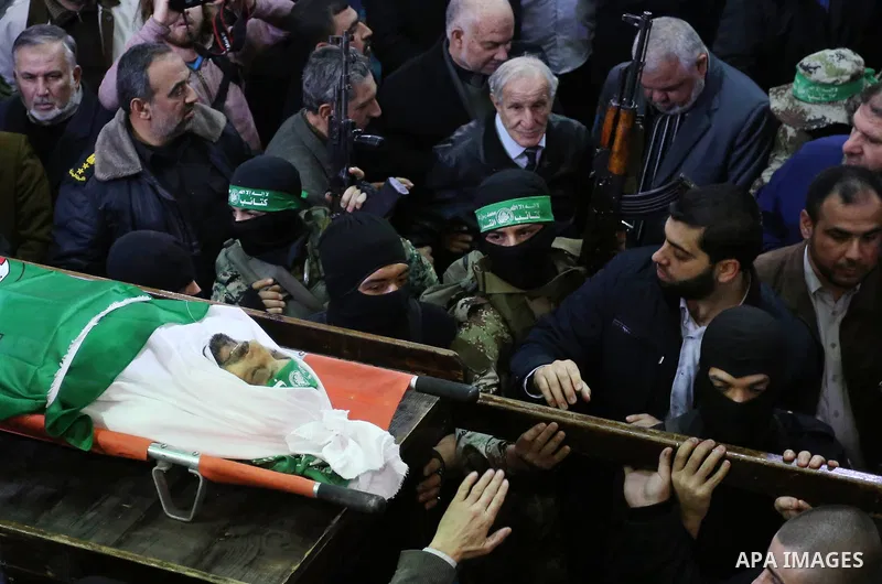 Palestinian militants from the Ezzedine al-Qassam Brigades, the armed wing of the Hamas movement carry the body of Hamas senior leader Imad al-Alami during his funeral at the al-Omari mosque in Gaza City on January 30, 2...