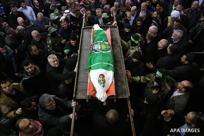 Palestinian militants from the Ezzedine al-Qassam Brigades, the armed wing of the Hamas movement carry the body of Hamas senior leader Imad al-Alami during his funeral at the al-Omari mosque in Gaza City on January 30, 2...