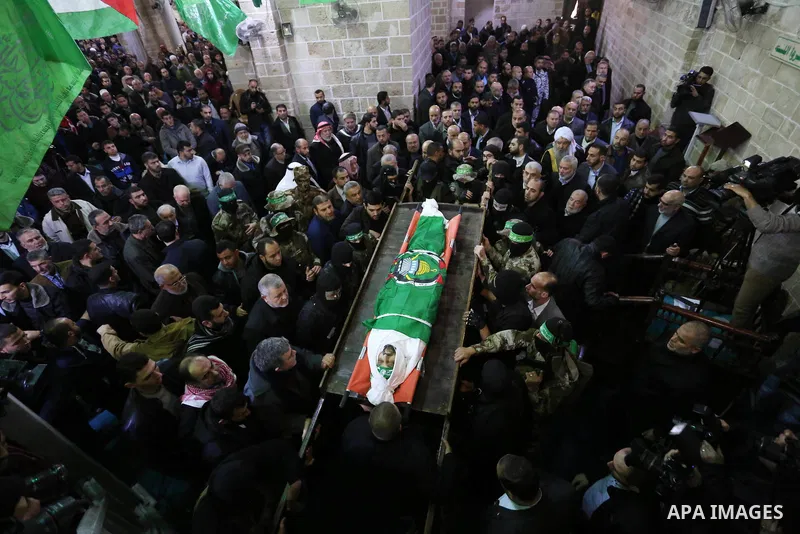 Palestinian militants from the Ezzedine al-Qassam Brigades, the armed wing of the Hamas movement carry the body of Hamas senior leader Imad al-Alami during his funeral at the al-Omari mosque in Gaza City on January 30, 2...