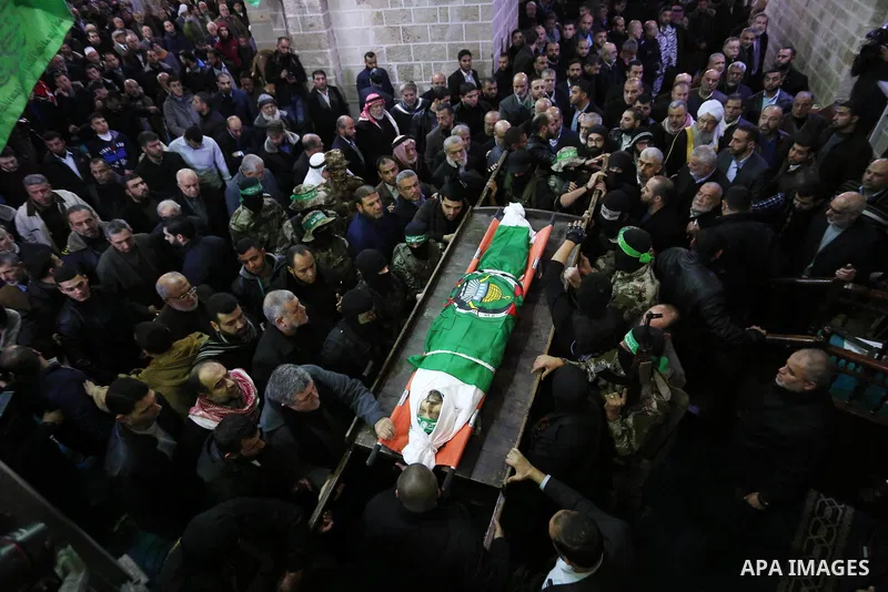 Palestinian militants from the Ezzedine al-Qassam Brigades, the armed wing of the Hamas movement carry the body of Hamas senior leader Imad al-Alami during his funeral at the al-Omari mosque in Gaza City on January 30, 2...