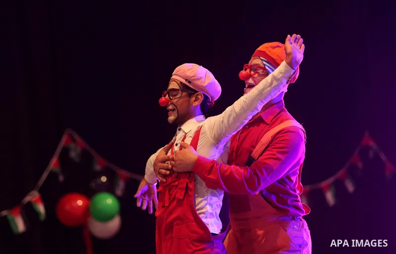 Palestinians dressed as clowns perform during a "joy and fun" festival for Palestinian school students which organized by Gaza Municipality in Gaza city on January 30, 2018. Photo by Ashraf Amra