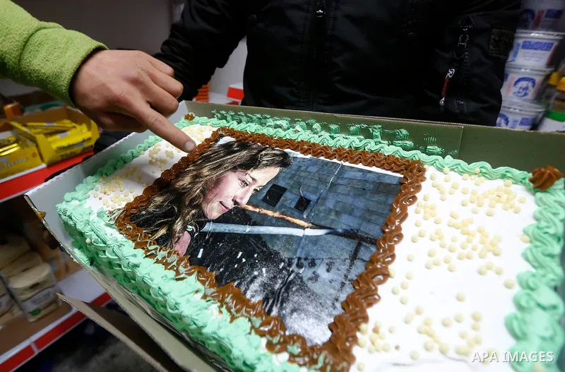 A Palestinian man displays a cake with the picture of Palestinian teen Ahed Tamimi, who is detained by Israel, during a symbolic birthday party for Tamimi in the West Bank city of Hebron January 30, 2018. Photo by Wisam...