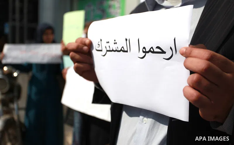 Palestinians hold banners during a protest against Jawwal's decision to add 16% VAT to its customers in the Gaza Strip in Gaza city on January 31, 2018. Photo by Mahmoud Ajour