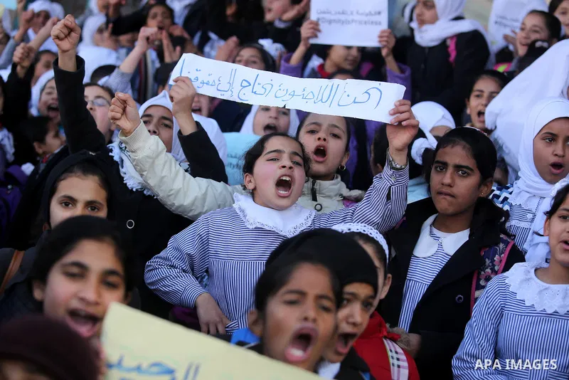 Palestinian school students shout slogans and hold placards in a protest against the US move to freeze funding for the UN agency for Palestinian refugees on January 31, 2018 at the al-Nusairat refugee camp, in central Ga...