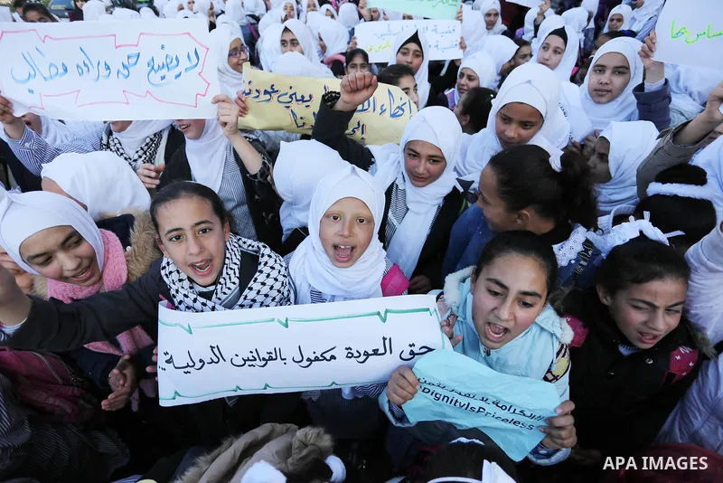 Palestinian school students shout slogans and hold placards in a protest against the US move to freeze funding for the UN agency for Palestinian refugees on January 31, 2018 at the al-Nusairat refugee camp, in central Ga...