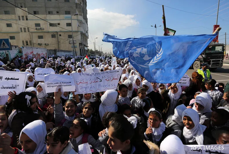 Palestinian school students shout slogans and hold placards in a protest against the US move to freeze funding for the UN agency for Palestinian refugees on January 31, 2018 at the al-Nusairat refugee camp, in central Ga...
