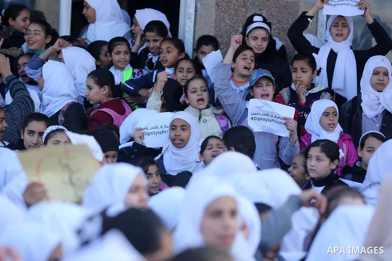 Palestinian school students shout slogans and hold placards in a protest against the US move to freeze funding for the UN agency for Palestinian refugees on January 31, 2018 at the al-Nusairat refugee camp, in central Ga...