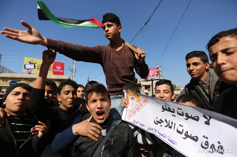 Palestinian school students shout slogans and hold placards in a protest against the US move to freeze funding for the UN agency for Palestinian refugees on January 31, 2018 at the al-Nusairat refugee camp, in central Ga...