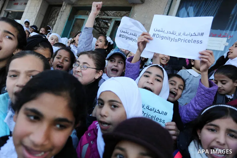 Palestinian school students shout slogans and hold placards in a protest against the US move to freeze funding for the UN agency for Palestinian refugees on January 31, 2018 at the al-Nusairat refugee camp, in central Ga...