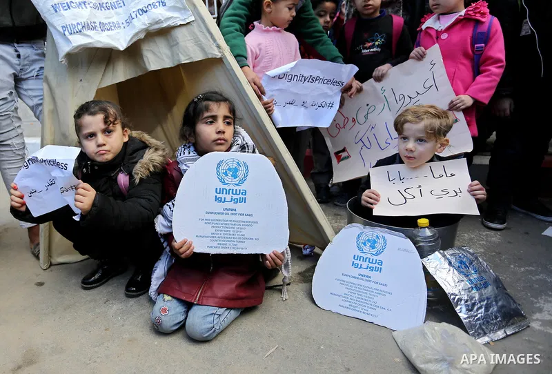 Palestinian school students shout slogans and hold placards in a protest against the US move to freeze funding for the UN agency for Palestinian refugees on January 31, 2018 at the al-Nusairat refugee camp, in central Ga...