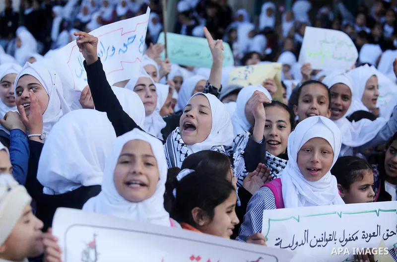 Palestinian school students shout slogans and hold placards in a protest against the US move to freeze funding for the UN agency for Palestinian refugees on January 31, 2018 at the al-Nusairat refugee camp, in central Ga...