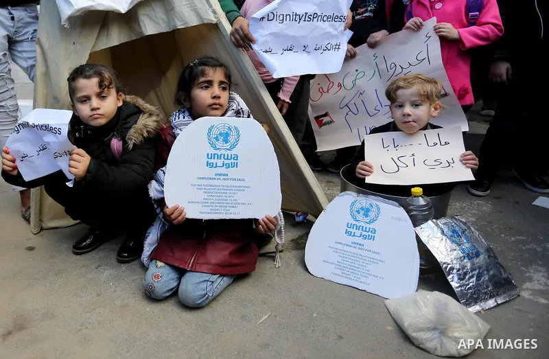 Palestinian school students shout slogans and hold placards in a protest against the US move to freeze funding for the UN agency for Palestinian refugees on January 31, 2018 at the al-Nusairat refugee camp, in central Ga...