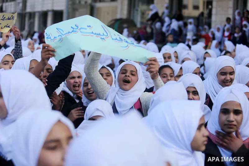 Palestinian school students shout slogans and hold placards in a protest against the US move to freeze funding for the UN agency for Palestinian refugees on January 31, 2018 at the al-Nusairat refugee camp, in central Ga...
