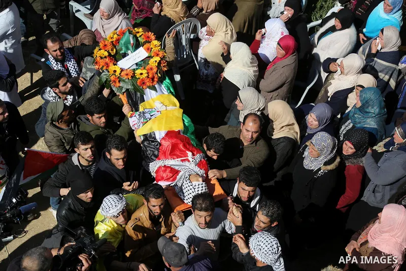 Mourners and relatives carry the body of a Palestinian youth during his funeral in the village of Mugheer, about 25 kilometres northeast of the city of Ramallah in the occupied West Bank on January 31, 2018, after he was...