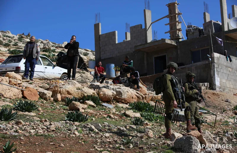 Israeli security forces stand guard as bulldozer demolish house which Israeli authorities said it was built without a permit during attempt to demolish it, at village of Beit Dajan, east of the West Bank city of Nablus o...