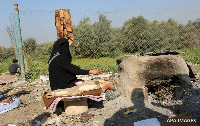 A Palestinian woman bakes bread in her neighborhood which experiences power shortages, in Johr El-Deek in Gaza on February 1, 2018. Photo by Ashraf Amra
