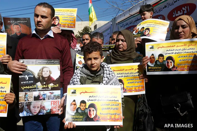 Palestinians take part in a protest of solidarity with prisoner Esraa Al-Jabbais held in Israeli jails in front of Red cross office, in the West Bank city of Hebron, on February 1, 2018. Photo by Wisam Hashlamoun