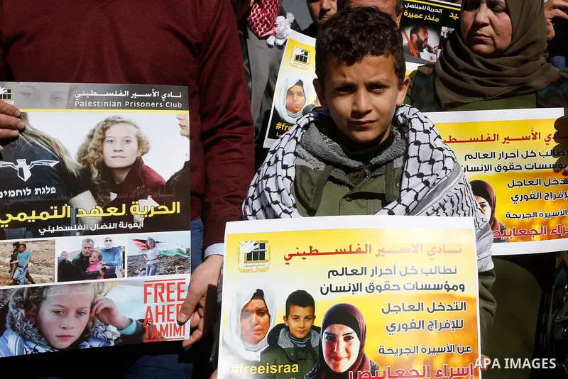 Palestinians take part in a protest of solidarity with prisoner Esraa Al-Jabbais held in Israeli jails in front of Red cross office, in the West Bank city of Hebron, on February 1, 2018. Photo by Wisam Hashlamoun