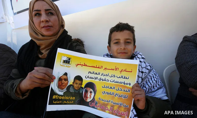Palestinians take part in a protest of solidarity with prisoner Esraa Al-Jabbais held in Israeli jails in front of Red cross office, in the West Bank city of Hebron, on February 1, 2018. Photo by Wisam Hashlamoun
