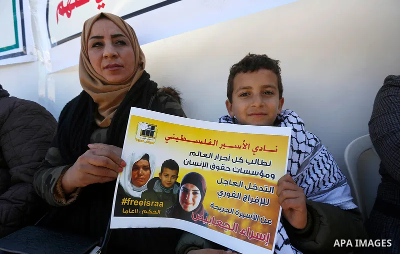 Palestinians take part in a protest of solidarity with prisoner Esraa Al-Jabbais held in Israeli jails in front of Red cross office, in the West Bank city of Hebron, on February 1, 2018. Photo by Wisam Hashlamoun