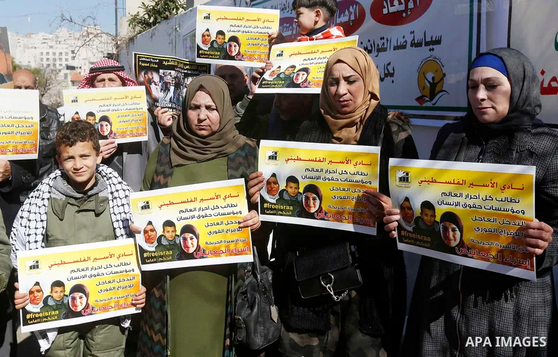 Palestinians take part in a protest of solidarity with prisoner Esraa Al-Jabbais held in Israeli jails in front of Red cross office, in the West Bank city of Hebron, on February 1, 2018. Photo by Wisam Hashlamoun