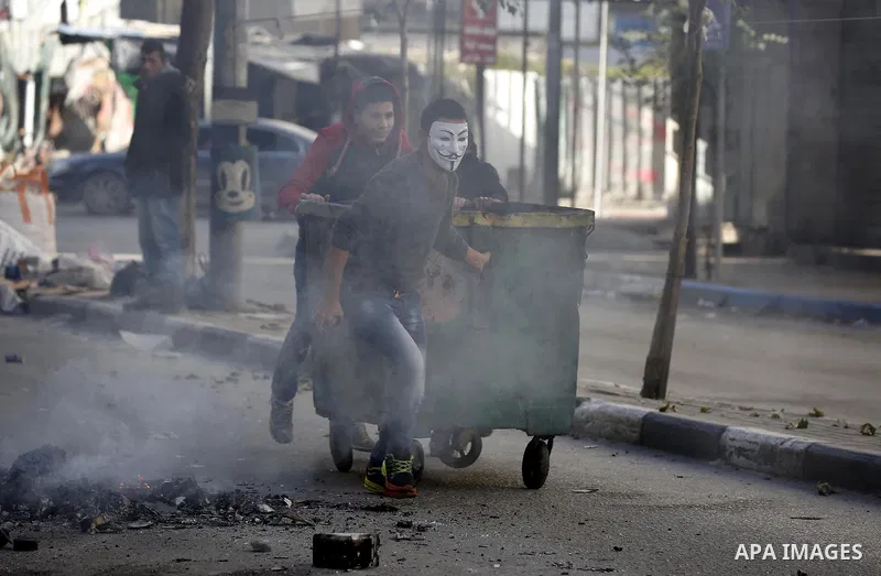 Palestinian protesters push a barricade during clashes with Israeli security forces in the West Bank city of Hebron on February 2, 2018 2018 as demonstrations continue over the US president's controversial recognition of...
