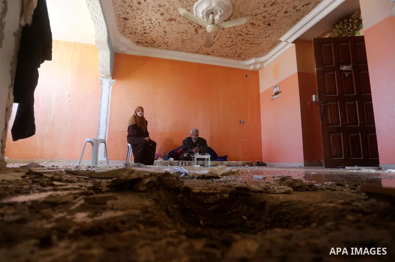 Palestinians sit inside their apartment which was damaged after an attack carried out by the Israeli army in Beit Hanun in the northern Gaza Strip on February 2, 2018. Israeli forces struck a Hamas position in Gaza early...