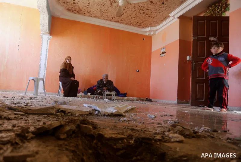 Palestinians sit inside their apartment which was damaged after an attack carried out by the Israeli army in Beit Hanun in the northern Gaza Strip on February 2, 2018. Israeli forces struck a Hamas position in Gaza early...