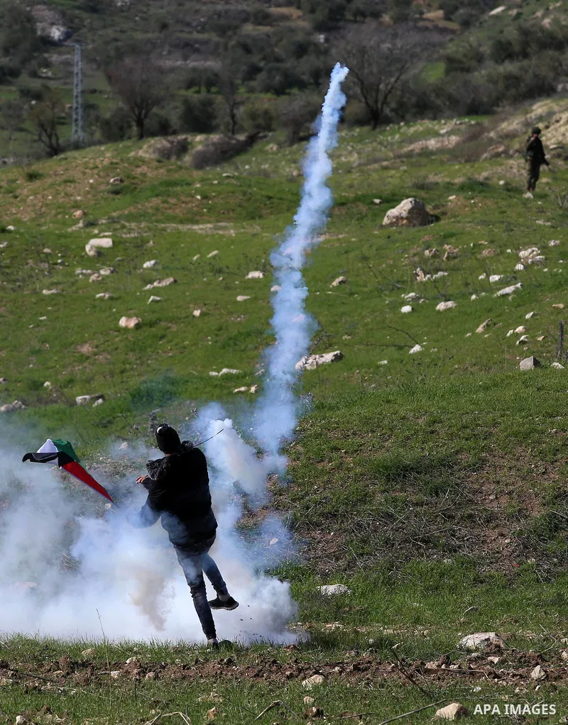 A Palestinian protester throws back a teargas canister towards Israeli security forces during clashes following a demonstration near the Hawara checkpoint, south of the West Bank city of Nablus on February 2, 2018, as de...