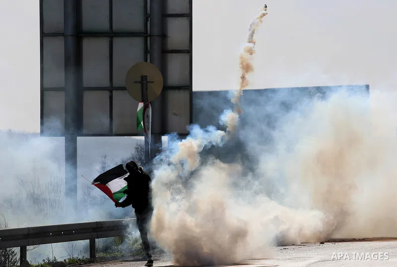 A Palestinian protester throws back a teargas canister towards Israeli security forces during clashes following a demonstration near the Hawara checkpoint, south of the West Bank city of Nablus on February 2, 2018, as de...