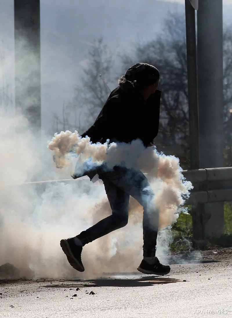 A Palestinian protester throws back a teargas canister towards Israeli security forces during clashes following a demonstration near the Hawara checkpoint, south of the West Bank city of Nablus on February 2, 2018, as de...