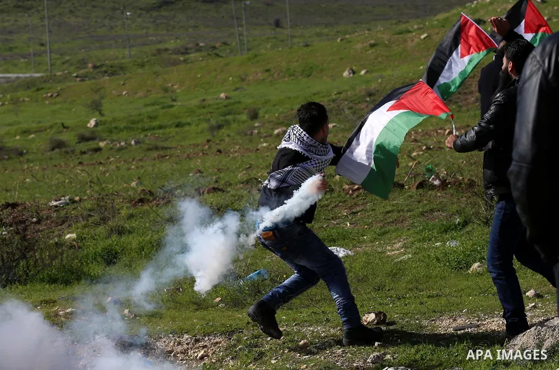 A Palestinian protester throws back a teargas canister towards Israeli security forces during clashes following a demonstration near the Hawara checkpoint, south of the West Bank city of Nablus on February 2, 2018, as de...