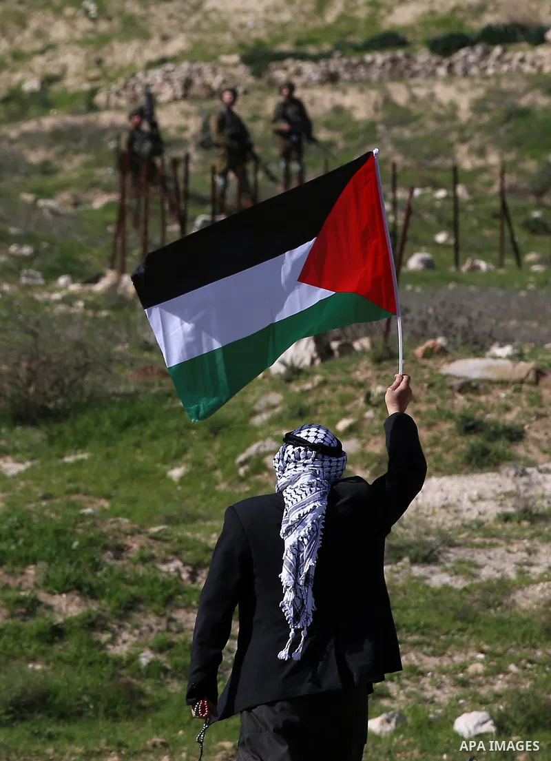 An elderly Palestinian man holds a Palestinian flag during clashes with Israeli security forces following a demonstration near the Hawara checkpoint, south of the West Bank city of Nablus on February 2, 2018, as demonstr...