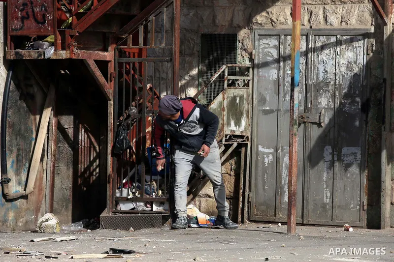 A Palestinian protester hurls stones towards Israeli security forces during a search operation for Palestinians suspected of carrying out attacks in the West Bank village of Zababdeh, north of Jenin on February 3, 2018....