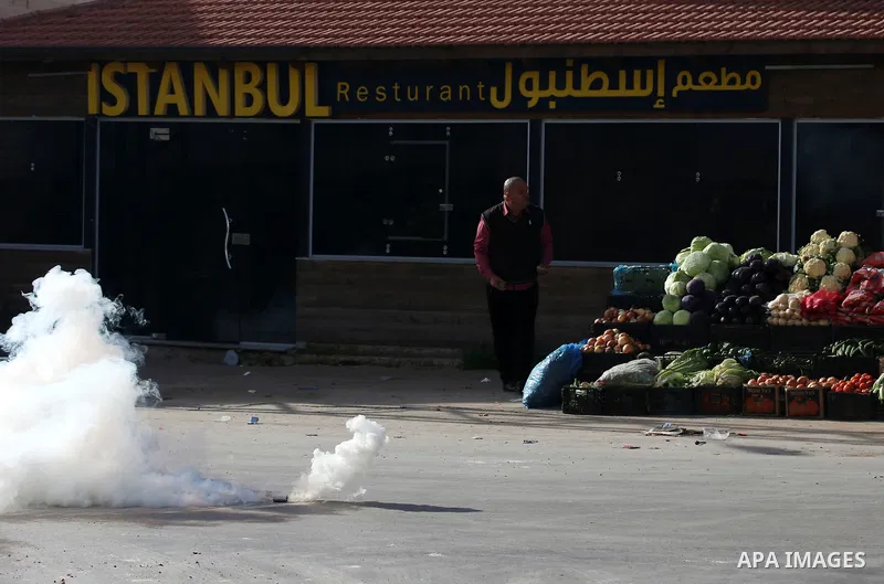 A Palestinian protester hurls stones towards Israeli security forces during a search operation for Palestinians suspected of carrying out attacks in the West Bank village of Zababdeh, north of Jenin on February 3, 2018....