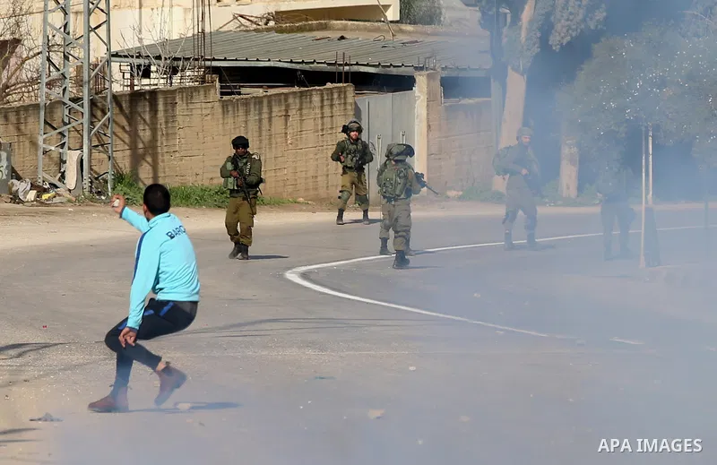 A Palestinian protester hurls stones towards Israeli security forces during a search operation for Palestinians suspected of carrying out attacks in the West Bank village of Zababdeh, north of Jenin on February 3, 2018....