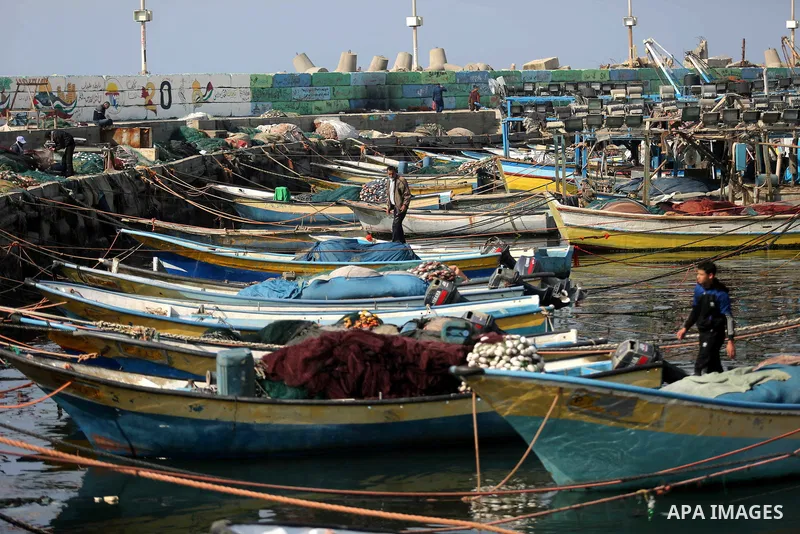 Palestinian fishermen work on their fishing boat in Gaza sea port on February 3, 2018. Photo by Ashraf Amra