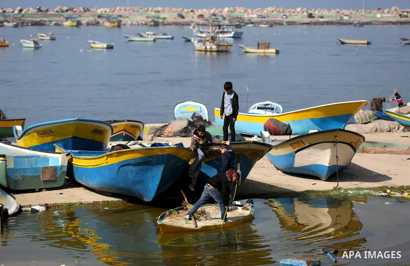 Palestinian boys play on fishing boats during a ceremony of support Palestinian fishermen project funded by the national islamic committee for development and social solidarity, in Gaza sea port on February 3, 2018. Phot...