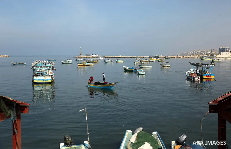 Palestinian fishermen work on their fishing boat in Gaza sea port on February 3, 2018. Photo by Ashraf Amra
