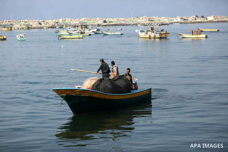 Palestinian fishermen work on their fishing boat in Gaza sea port on February 3, 2018. Photo by Ashraf Amra