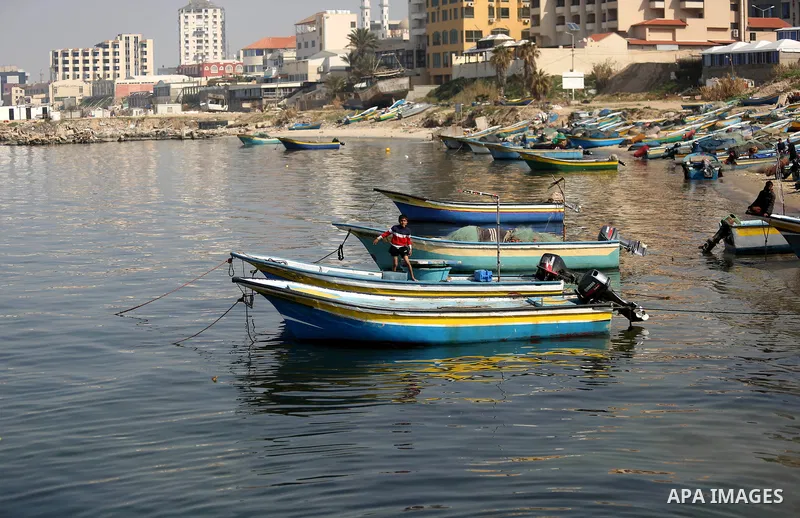 Palestinian fishermen work on their fishing boat in Gaza sea port on February 3, 2018. Photo by Ashraf Amra
