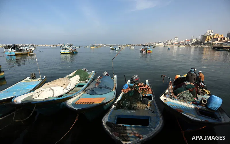 Palestinian fishermen work on their fishing boat in Gaza sea port on February 3, 2018. Photo by Ashraf Amra