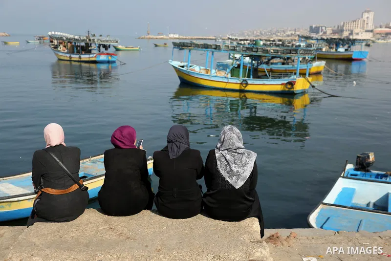 Palestinian women sit in Gaza sea port during a ceremony of support Palestinian fishermen project funded by the national islamic committee for development and social solidarity, on February 3, 2018. Photo by Ashraf Amra