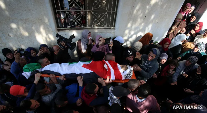 Mourners carry the body of Palestinian Ahmed Abu Obeid, 19, who was shot dead during clashes with Israeli security foces during his funeral, in the West Bank city of Jenin, on February 4, 2018. Photo by Shadi Jarar'ah