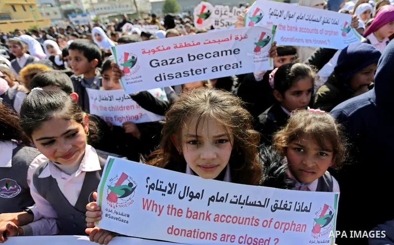 Palestinian students hold banners during a protest against Israeli blockade on Gaza strip, in Gaza city on February 4, 2018. Photo by Ashraf Amra