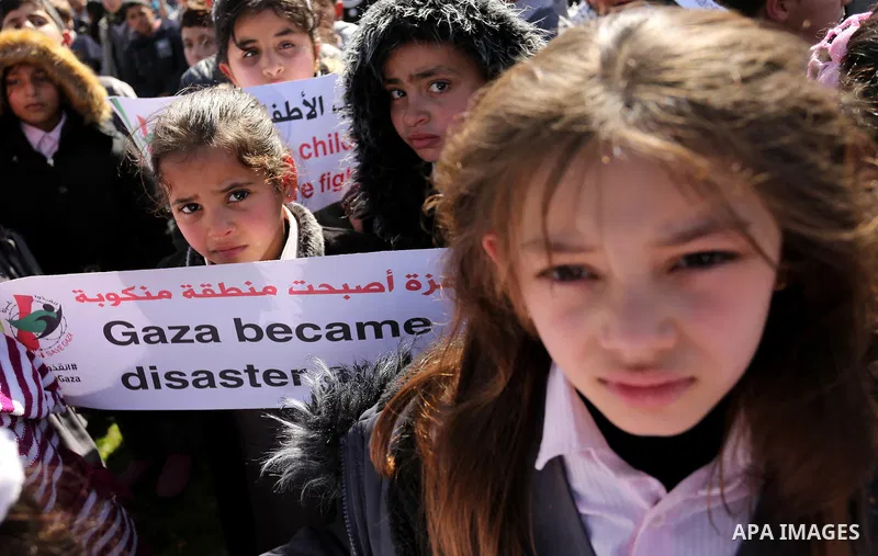 Palestinian students hold banners during a protest against Israeli blockade on Gaza strip, in Gaza city on February 4, 2018. Photo by Ashraf Amra