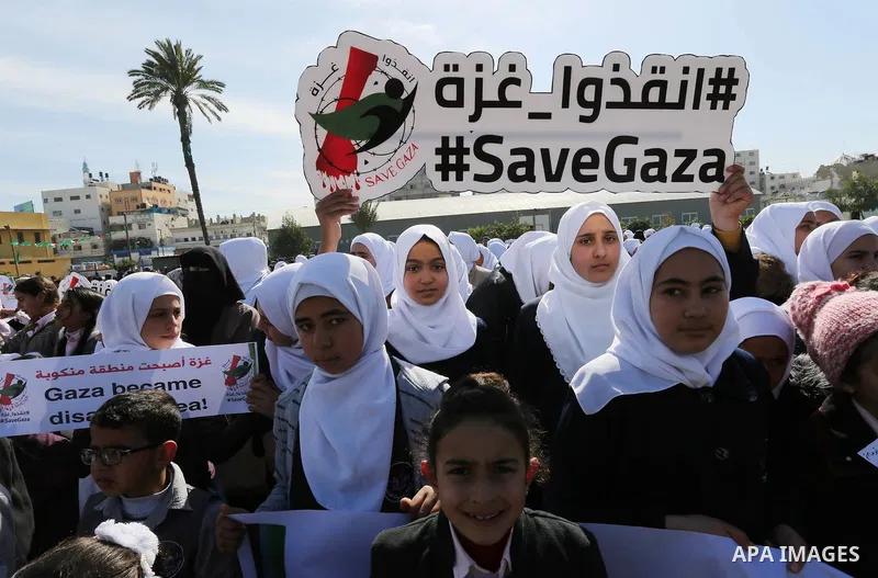 Palestinian students hold banners during a protest against Israeli blockade on Gaza strip, in Gaza city on February 4, 2018. Photo by Ashraf Amra