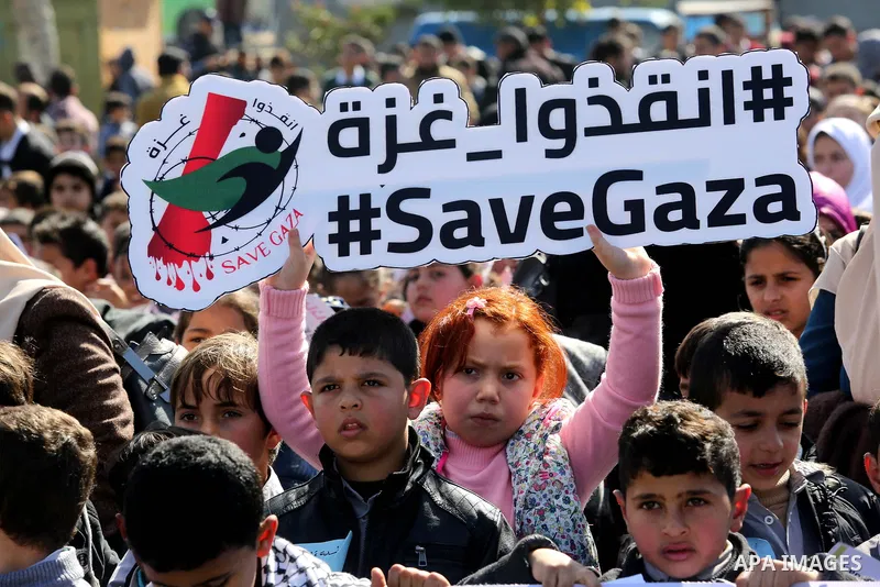Palestinian students hold banners during a protest against Israeli blockade on Gaza strip, in Gaza city on February 4, 2018. Photo by Ashraf Amra