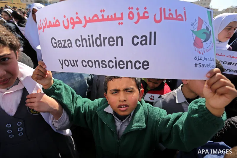 Palestinian students hold banners during a protest against Israeli blockade on Gaza strip, in Gaza city on February 4, 2018. Photo by Ashraf Amra
